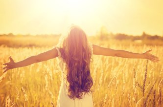 girl with open arms facing sun