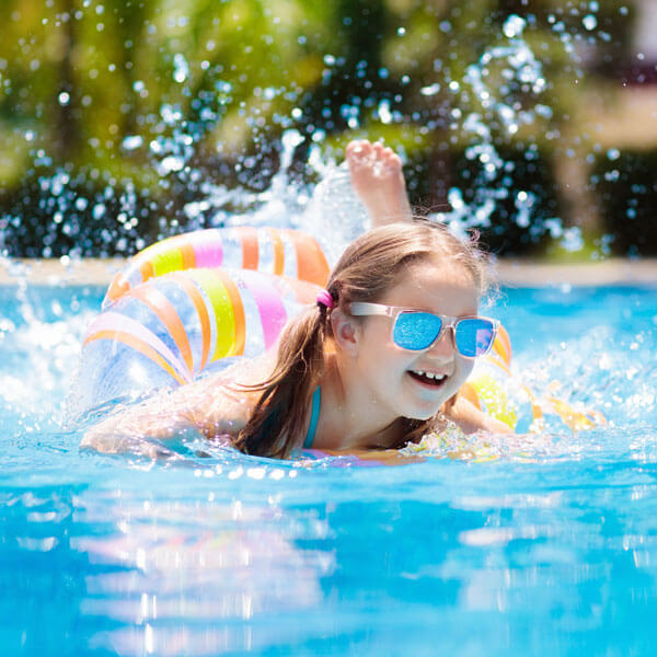 Child with colorful inflatable toy ring float in swimming pool