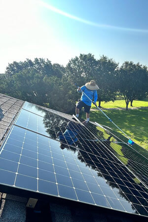 technician cleaning newly installed solar panels