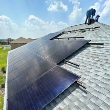 A side view of a room with solar panels installed on it and workers working at Ocala, FL.